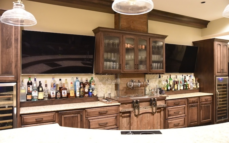 Two TVs on Wall behind Bar